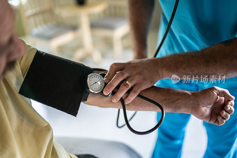 护士在养老院的卧室里测量老人的血压特写