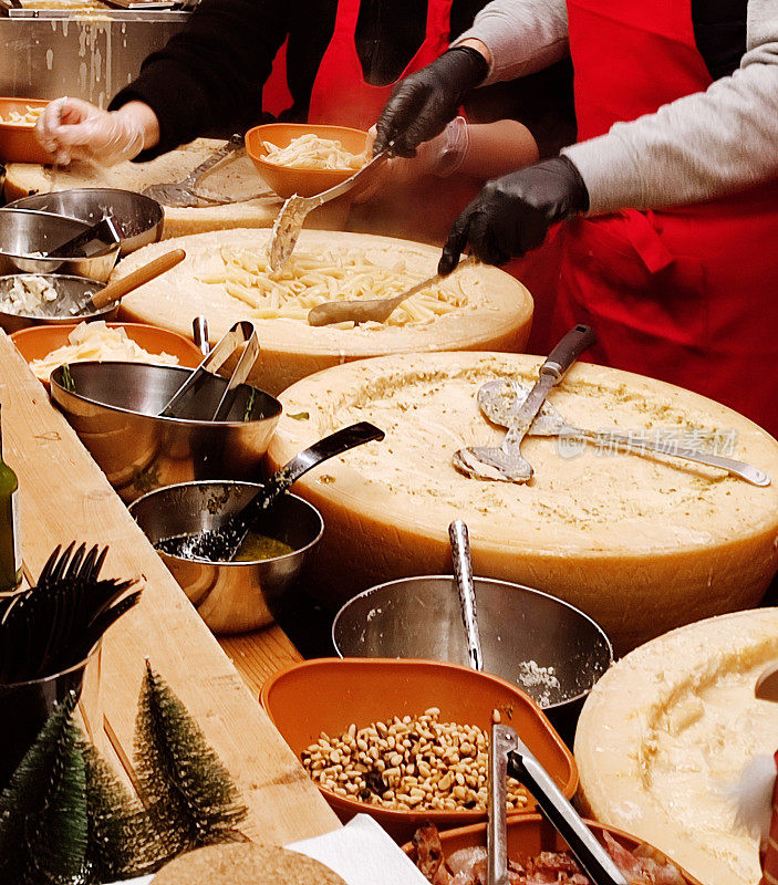 在比利时布鲁塞尔的街头摊位上制作通心粉和奶酪帕尔马干酪