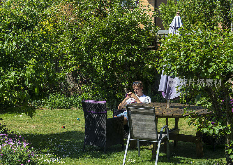 炎炎夏日，一个年轻人在住宅花园休息