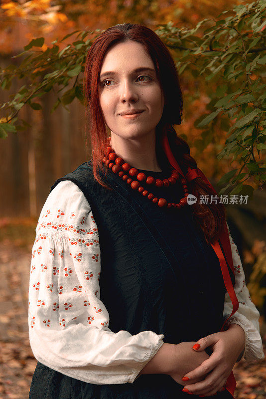 年轻的红发女子微笑着穿着传统的乌克兰刺绣衣服和红色珠子看向别处。古董。半身的肖像。