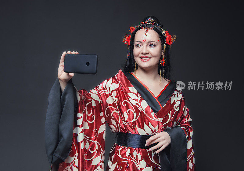 美丽的年轻快乐的女人在红色传统中国服装自拍