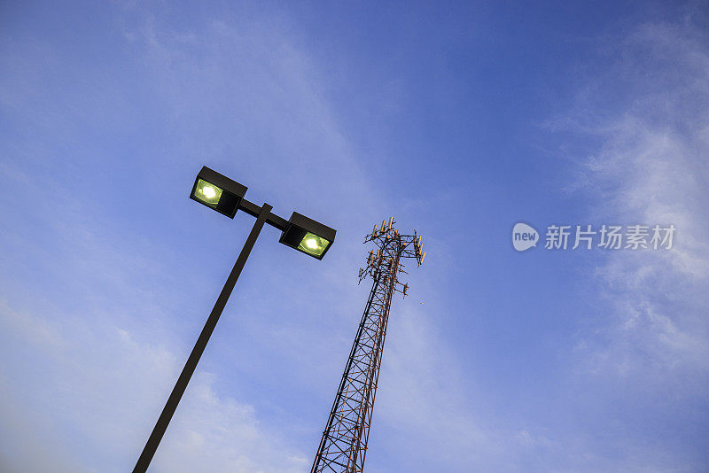 蓝天背景下的LED路灯和4g、5g通信塔、路灯灯杆。