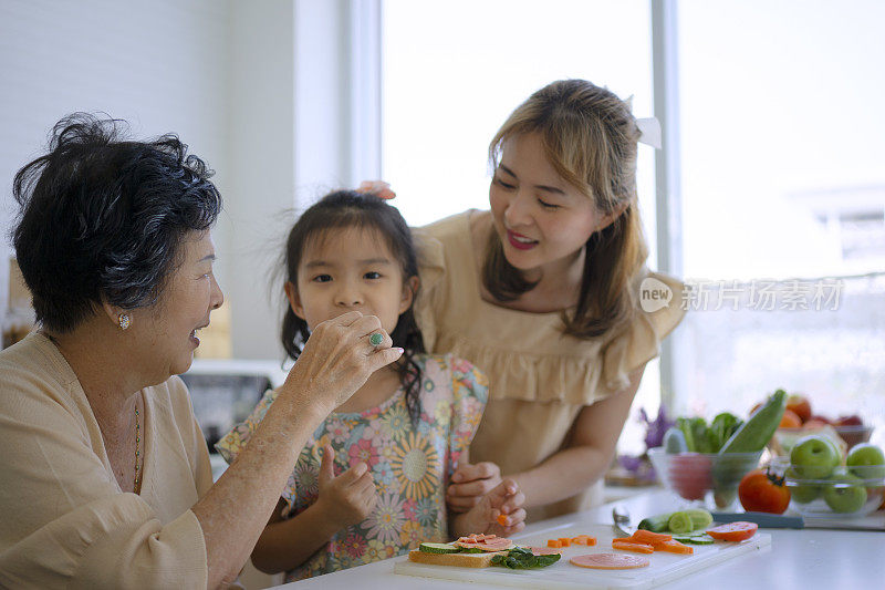 奶奶、妈妈和孙女在厨房准备食物。