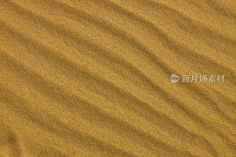 波浪状的平行图案在沙滩上的沙子上