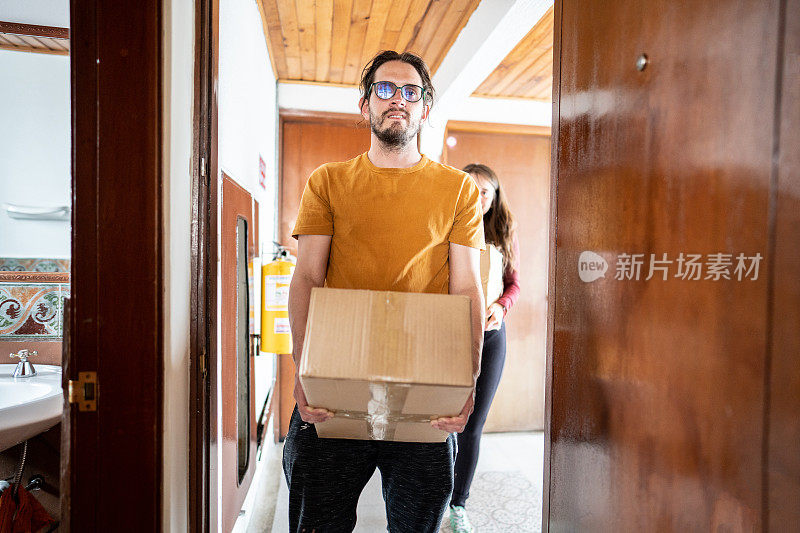 一个中年男子在新公寓搬箱子的照片