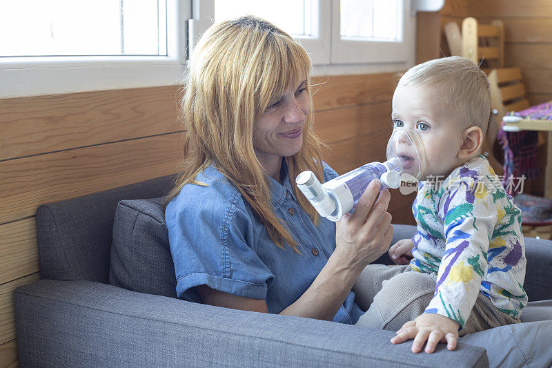 母亲教她的小儿子如何吸入治疗哮喘的药物
