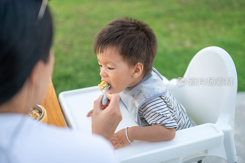 母亲在外面给她的男婴喂食