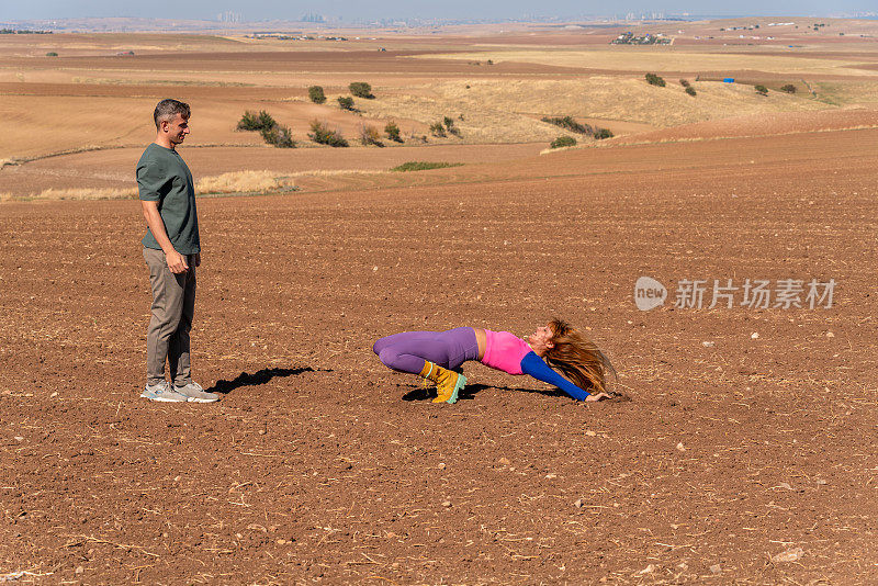 健康的生活方式:家庭野餐和锻炼。丈夫和妻子在耕地上玩耍。