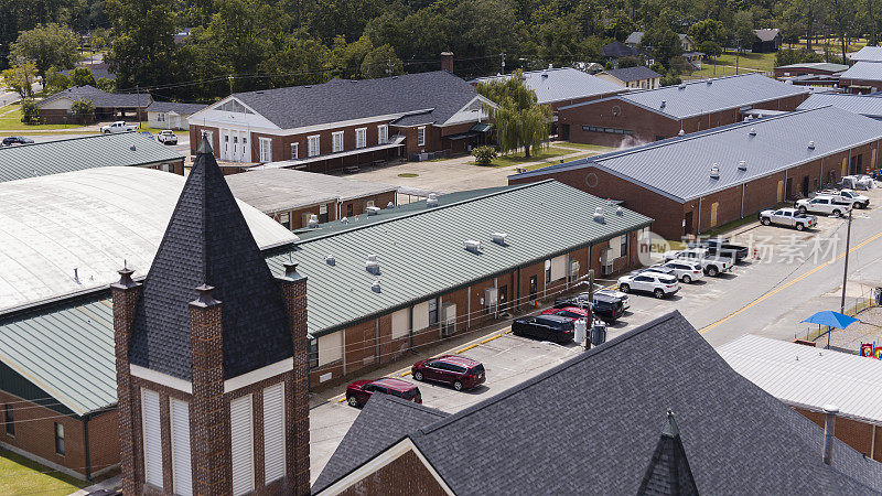 乔治亚州佩勒姆第一浸信会教堂后面的一层学校建筑和停车场。鸟瞰图