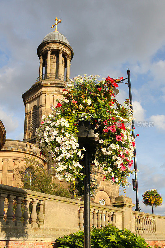 夏日里，什罗普郡什鲁斯伯里的StChads教堂外，挂满了夏日鲜花的美丽篮子。