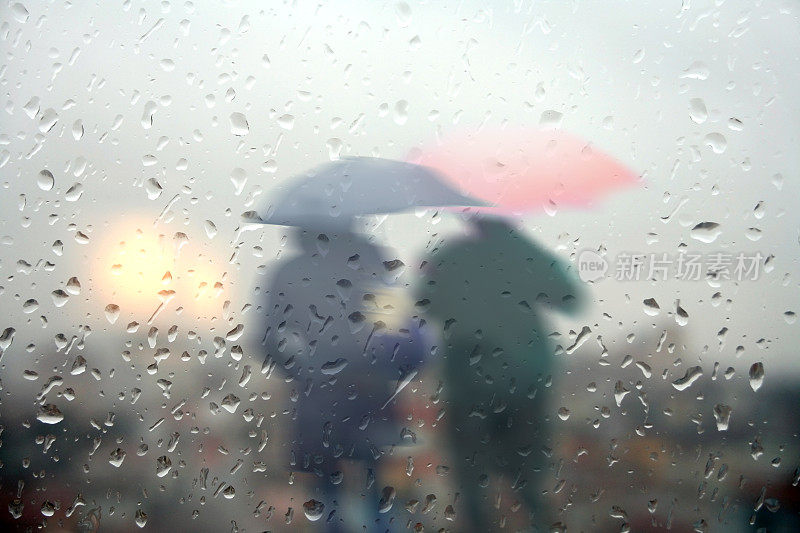 下雨天，人们在城市街道上打着伞