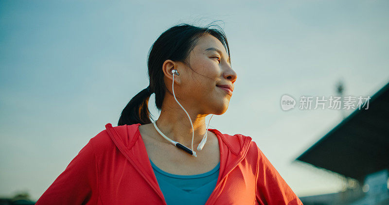 年轻的亚洲女运动员，跑步者，在运动后戴着耳机听音乐，放松。健康的锻炼。