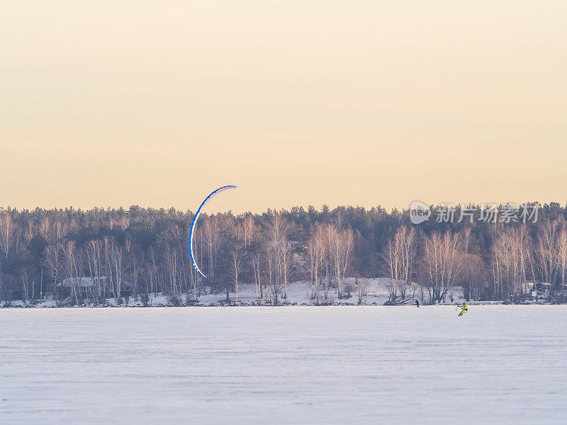 风筝冲浪者骑在滑雪板上。在冰湖上的雪地里打雪仗。