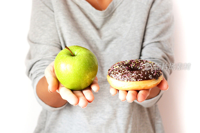 女性在健康水果和甜甜圈之间选择节食的概念