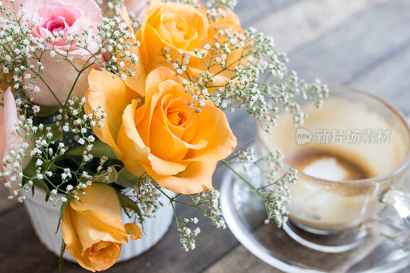 桌上有玫瑰，背景是咖啡，柔焦