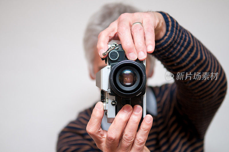 一个男人正在用一台复古相机拍照
