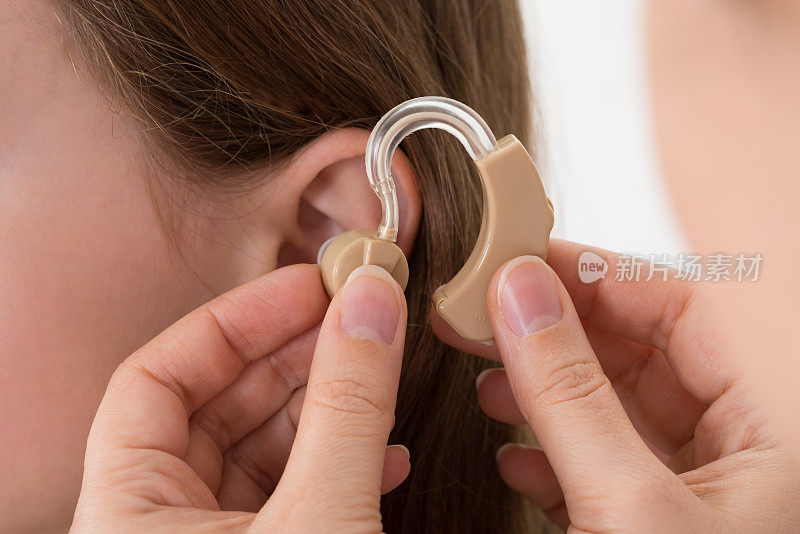 医生把助听器塞进一个女孩的耳朵