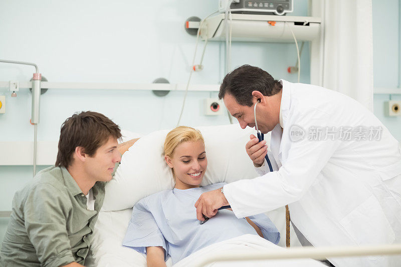 产科医生在使用听诊器时微笑