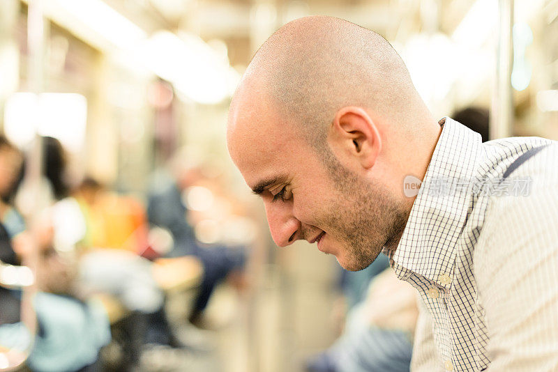 地铁上一个严肃的秃头男人