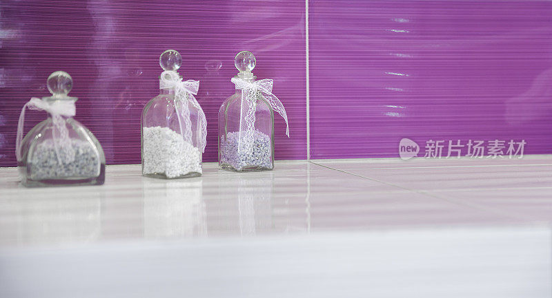 紫色的浴室，装着几罐浴盐