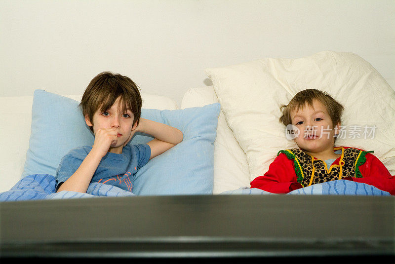 两个男孩在床上看电视
