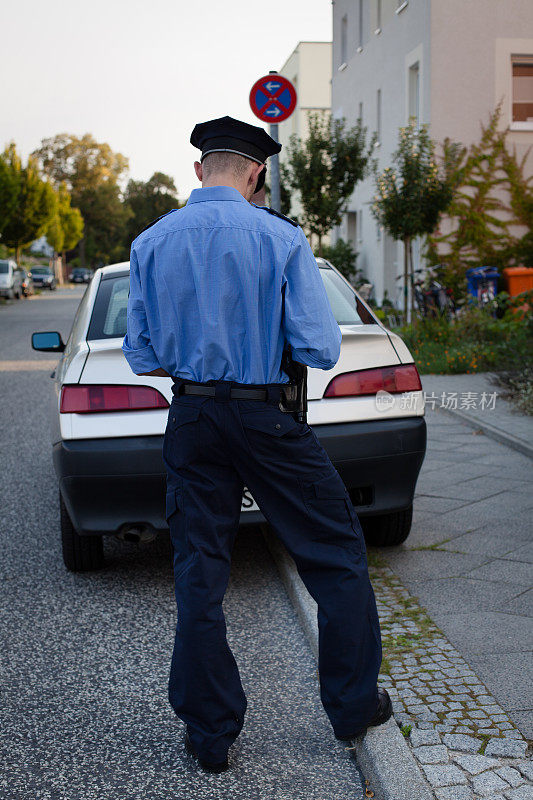 身着蓝色制服的警察开了一张停车罚单