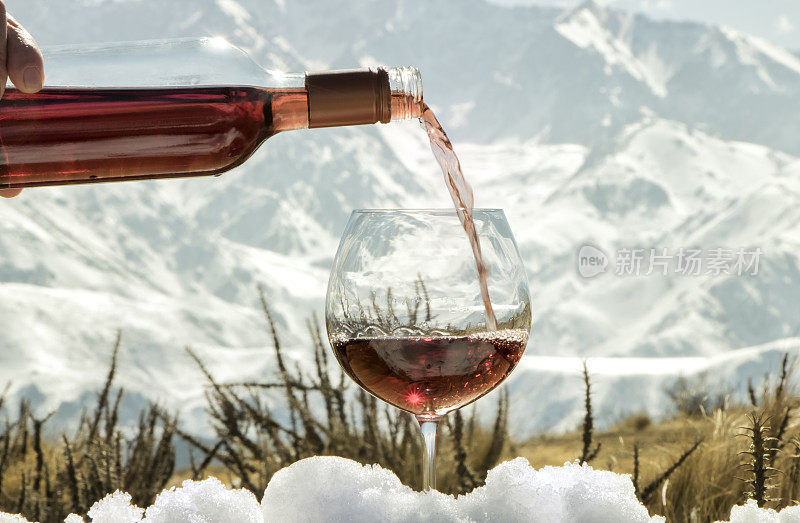 玻璃杯和一瓶rosé酒在雪地上