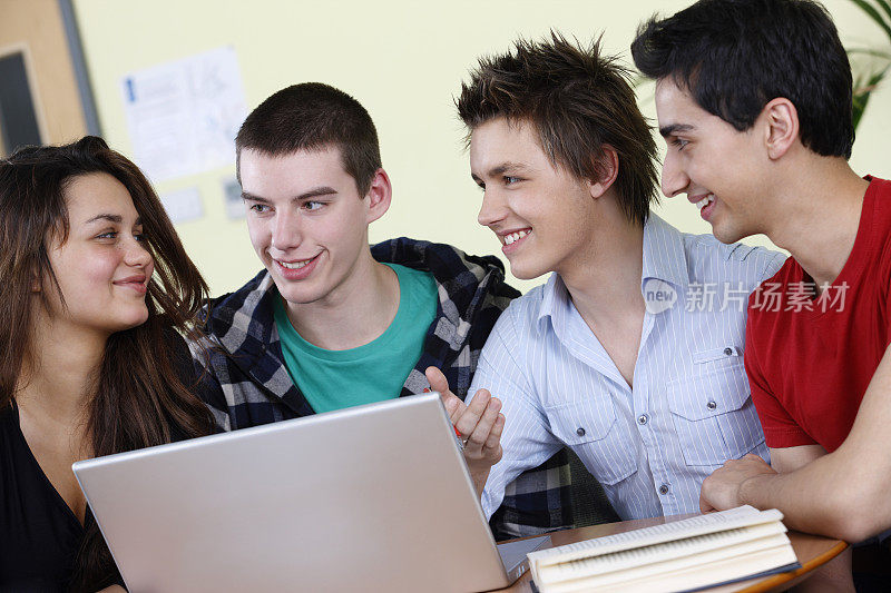年轻的学生在大学教室里用笔记本电脑学习