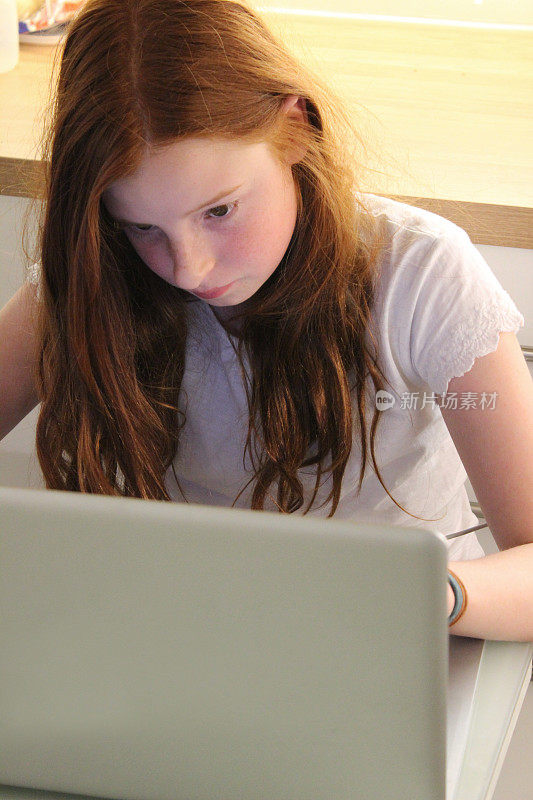 女孩在厨房用笔记本电脑做作业，学习