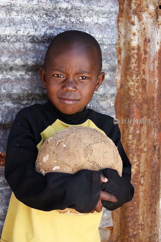 一个非洲小孩拿着足球