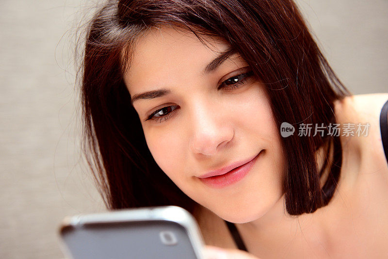 年轻女子使用智能手机，反映在眼睛里