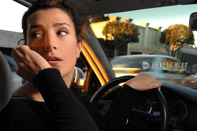 年轻女子开车时带着手机