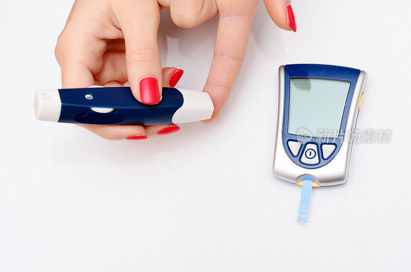 不健康妇女用数码设备和注射器做糖尿病测试