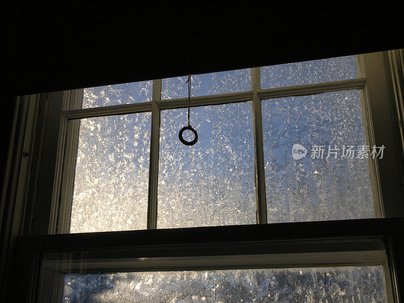 窗玻璃上覆盖着冬天的霜冻