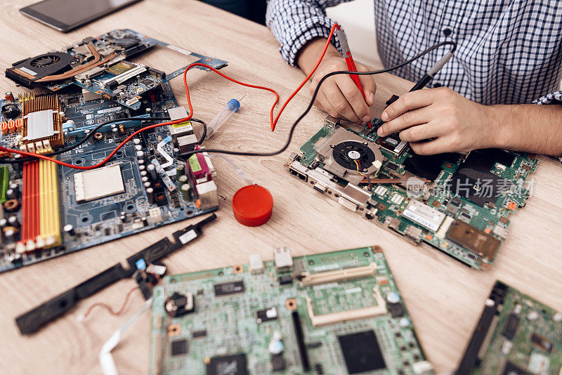 这个人是无线电技术员。一个男人正在修理印刷电路板。