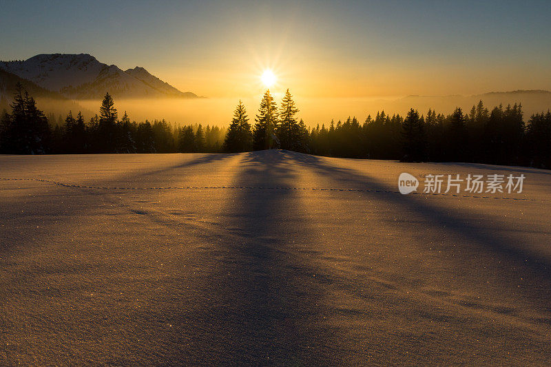 神奇的日落在雪山景观。阳光和背光。