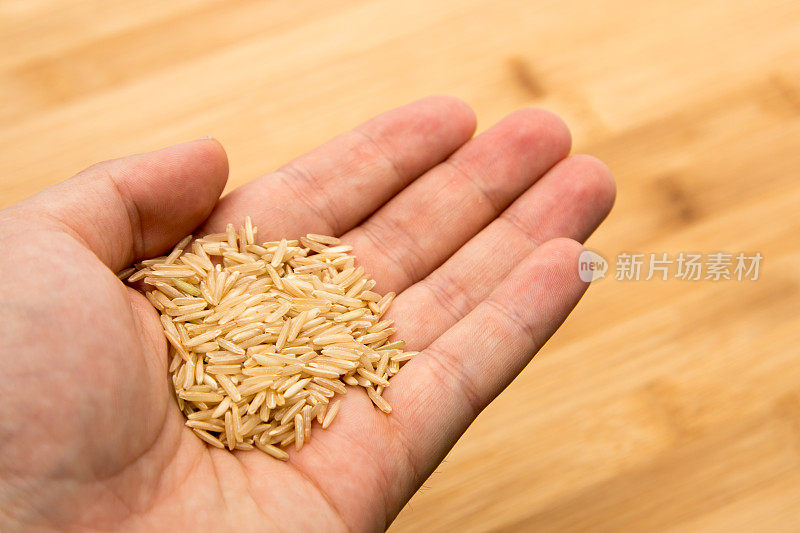一个人的手拿着米。