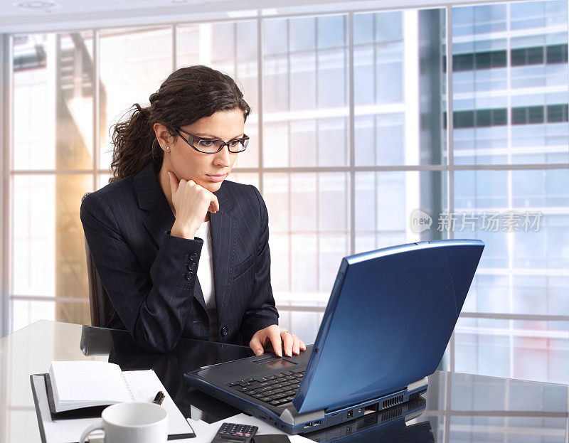 商务女性在大型建筑的办公室里使用笔记本电脑