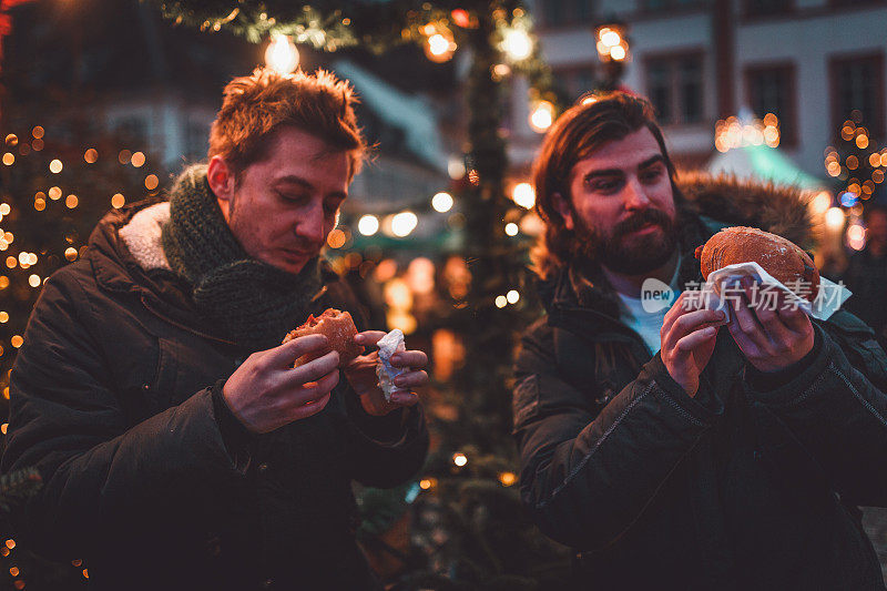 年轻人在德国享受圣诞市场的食物
