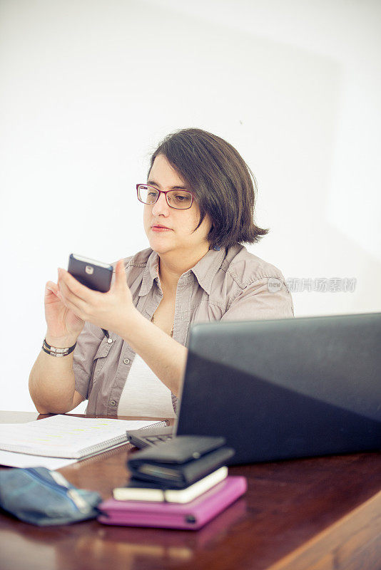 成年女性在办公室使用手机