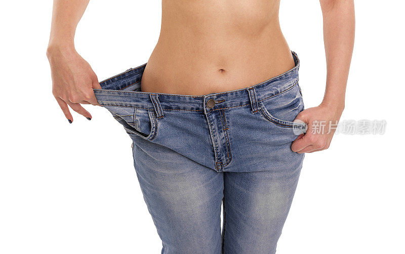 女人显示她减肥了。大的牛仔裤。