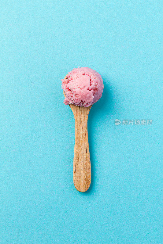 美味可口的草莓水果冰淇淋勺在蓝色时尚极简主义背景设计俯视图