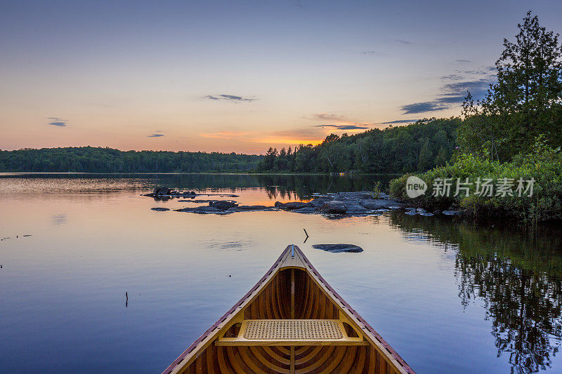日落时分，加拿大安大略湖上的雪松独木舟的船头