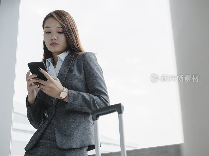 女人站在窗口使用智能手机