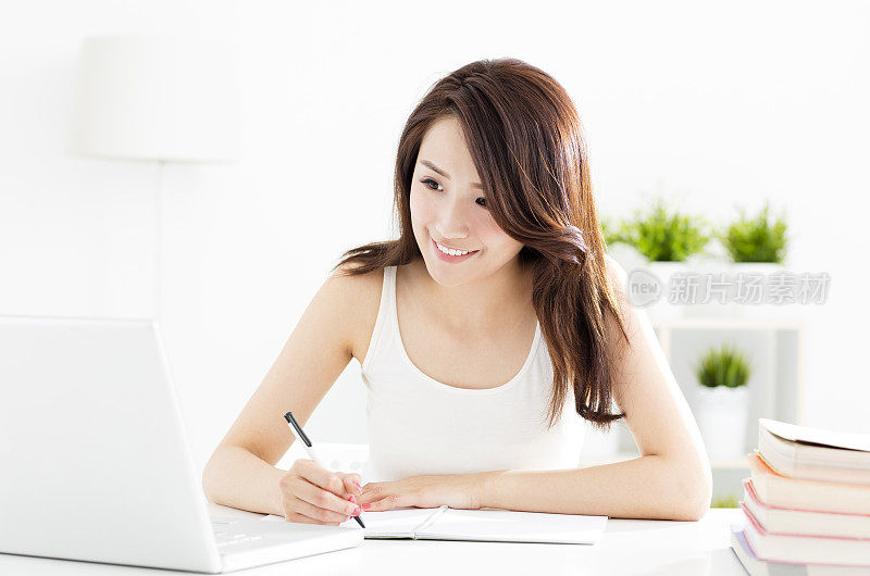 快乐的女学生学习与笔记本电脑