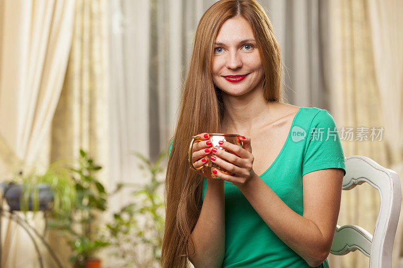 穿绿衣服的女人拿着一个铜杯