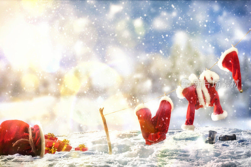 圣诞老人的衣服躺在雪景上的绳子上
