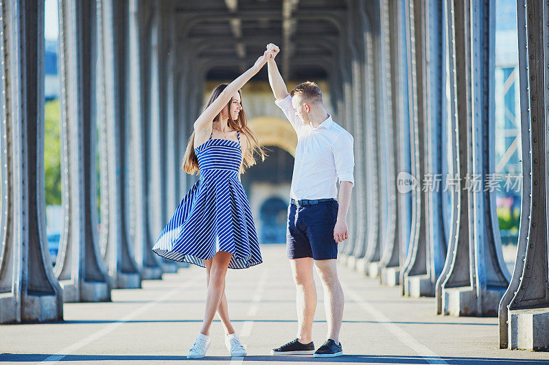 一对情侣在法国巴黎的比尔-哈基姆桥上散步