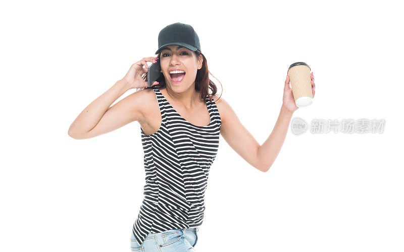 美丽的拉丁裔女性一边打电话一边拿着咖啡一边走路