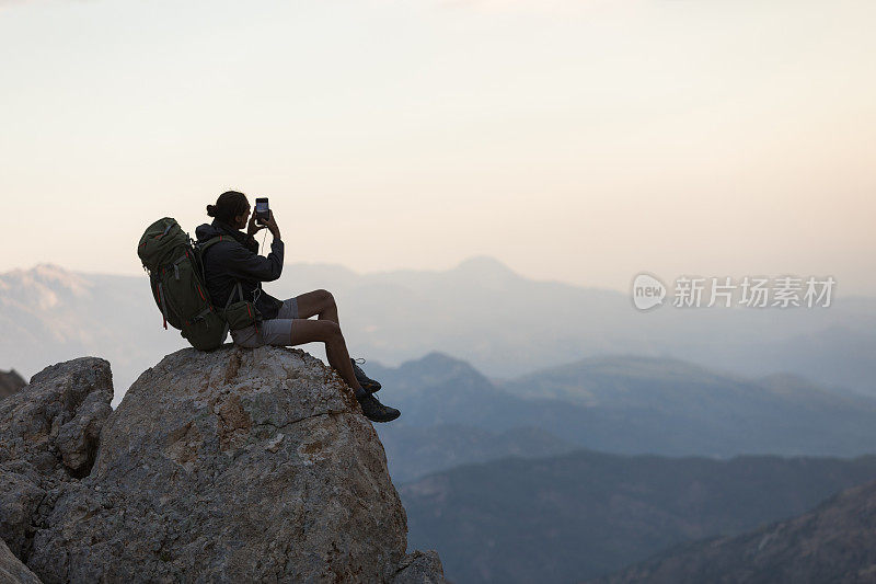 登山者在山顶使用智能手机